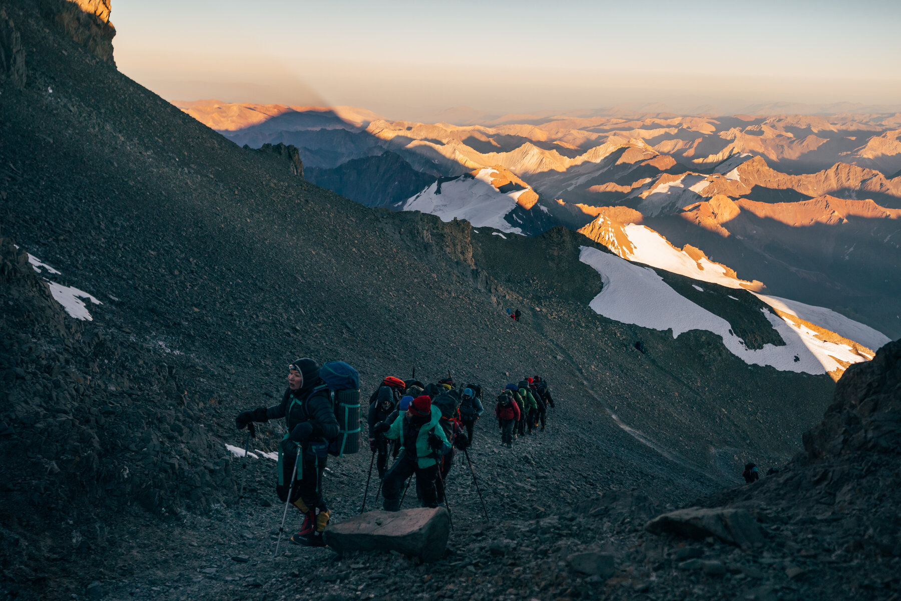 Team on the final approach to Aconcagua summit in golden morning light