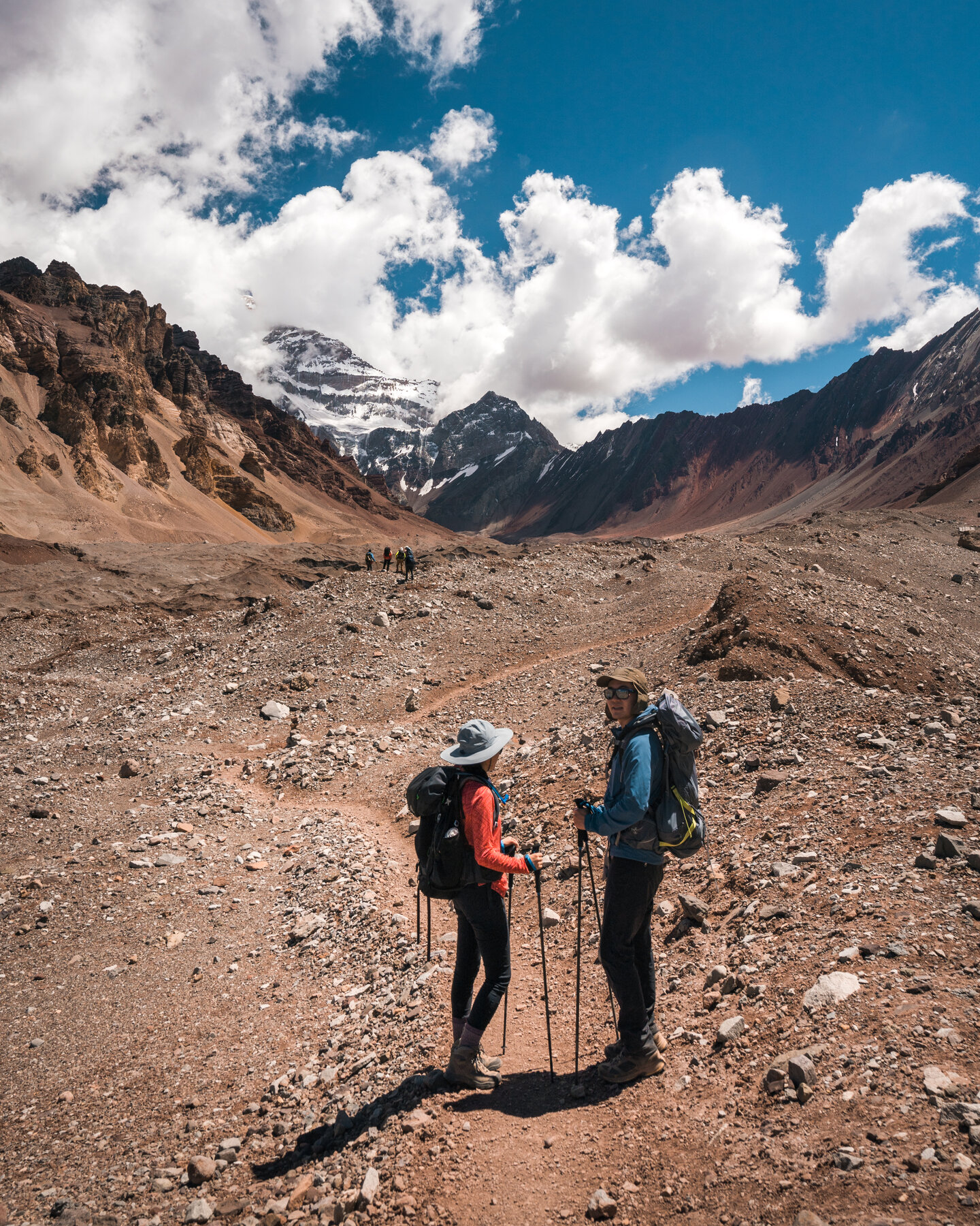 Jason and Grace trekking toward snow-capped Andean peaks
