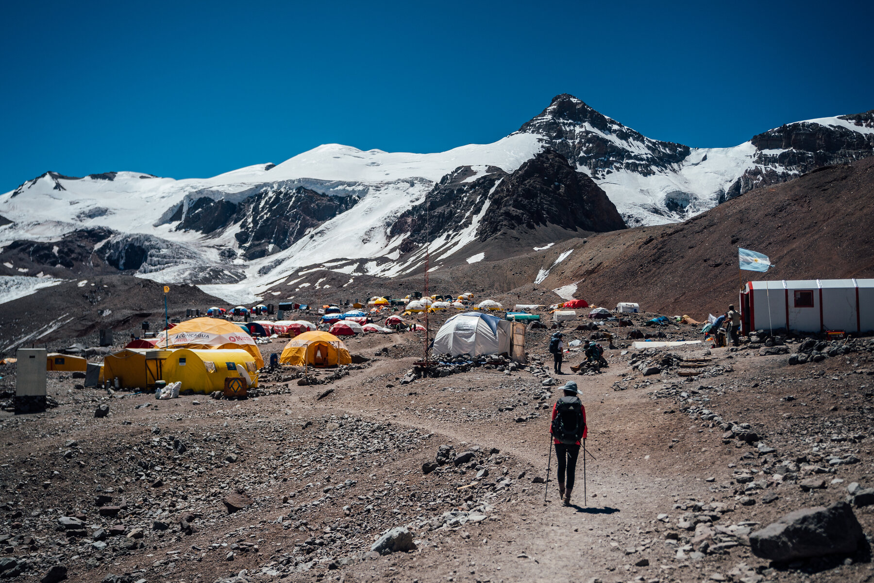 Sprawling Plaza de Mulas base camp with colorful tents and glaciers in the background