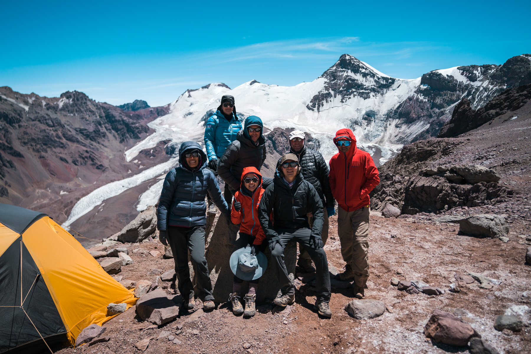 Full climbing team posing at high camp with Aconcagua summit behind