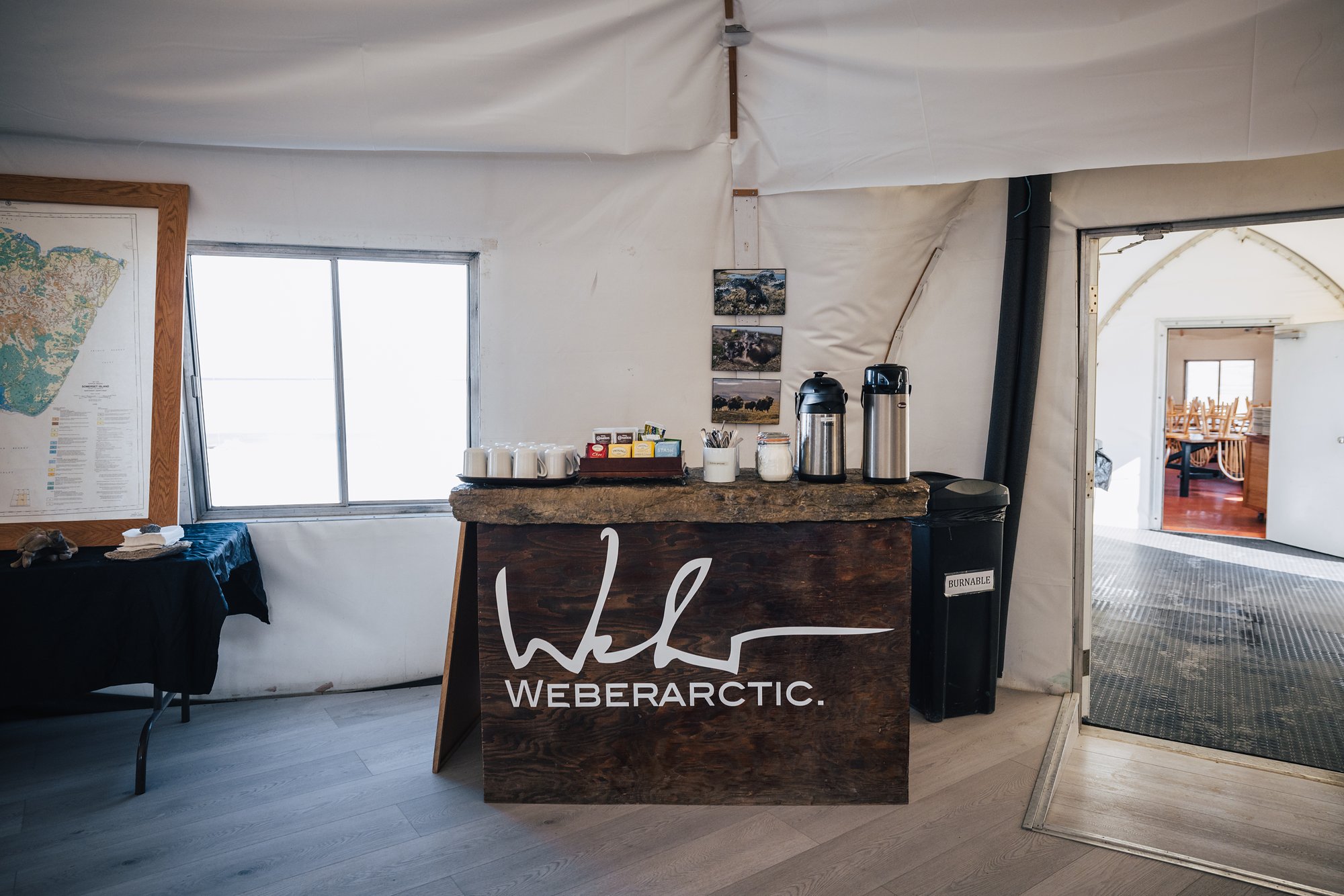 The coffee and tea station in the lodge with a carved Weber Arctic sign and a wall map