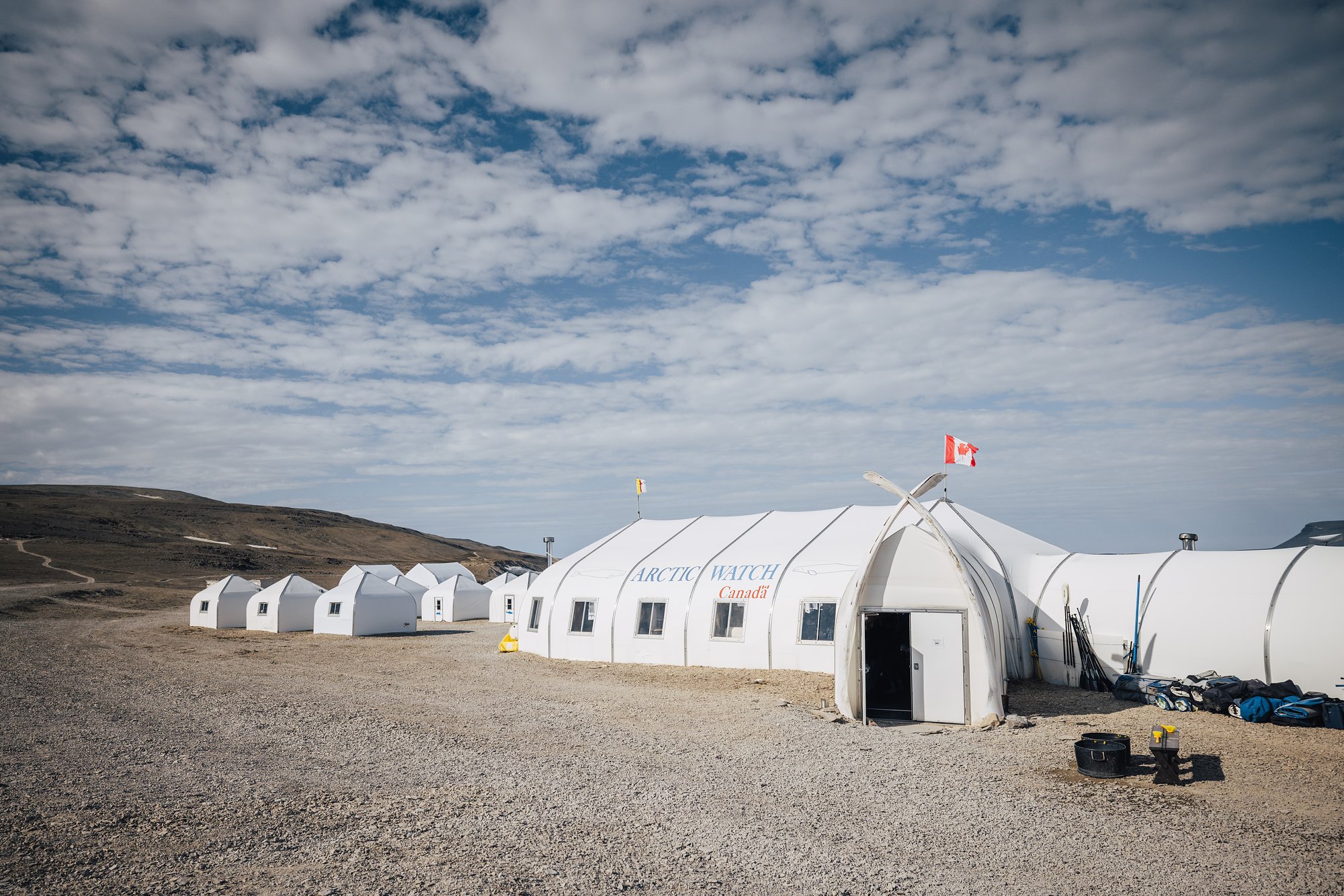 Arctic Watch's main lodge tent with an arch of whale bones over the door and Canadian and Nunavut flags on the roof