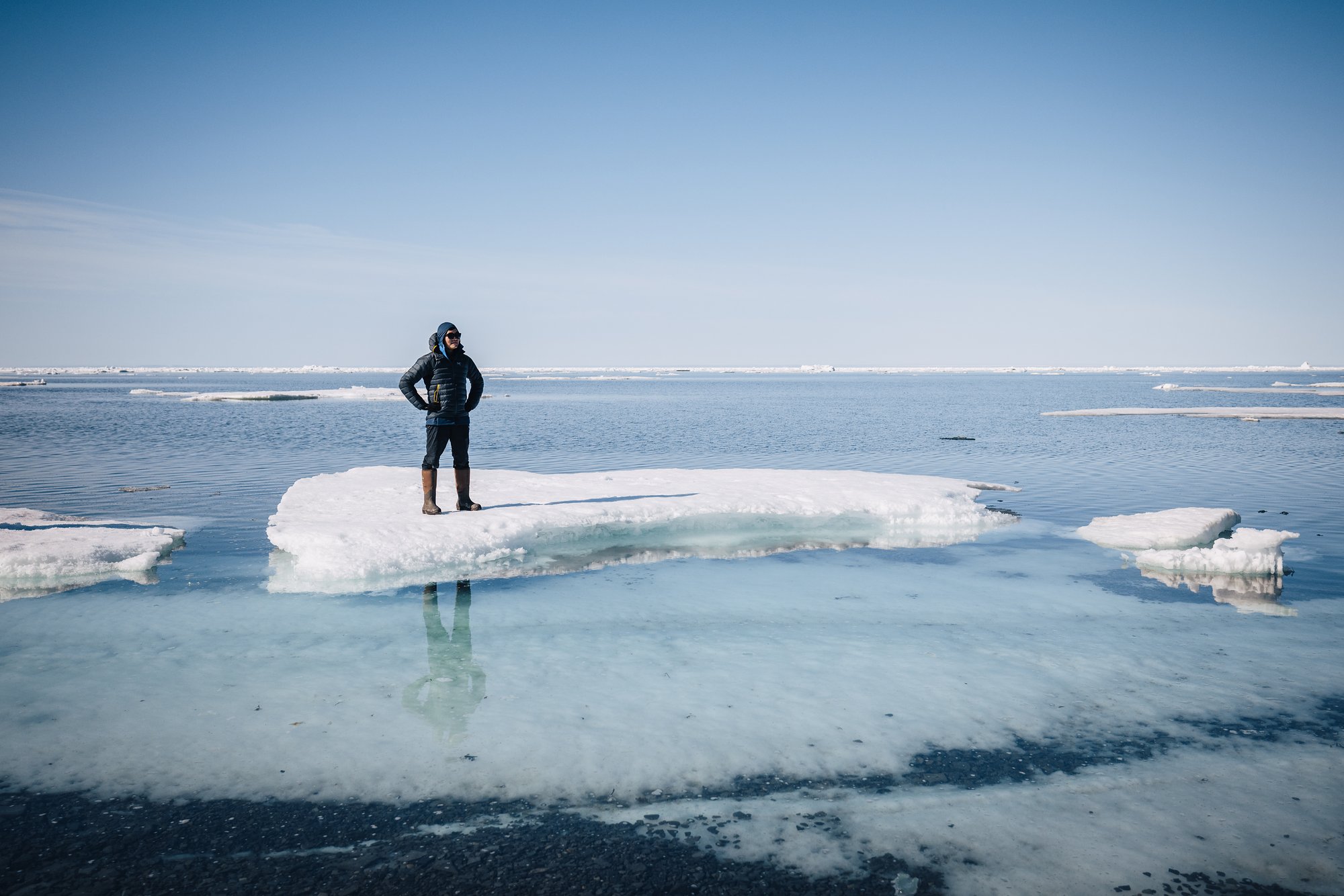 Standing on a stranded ice floe in the shallows, sea ice to the horizon
