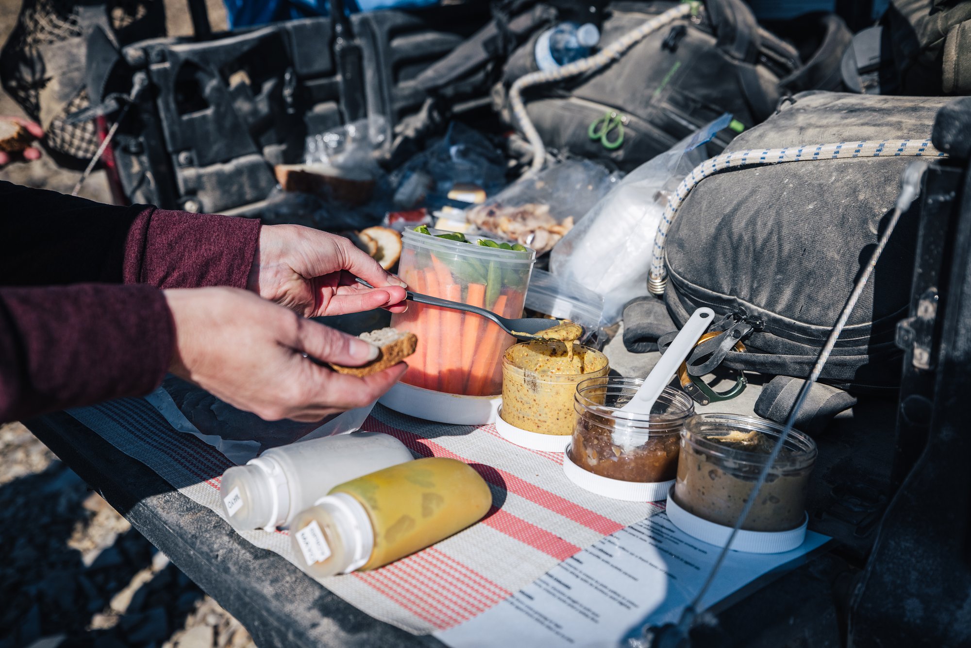 Making lunch on the buggy's tailgate, jars of condiments and vegetable sticks