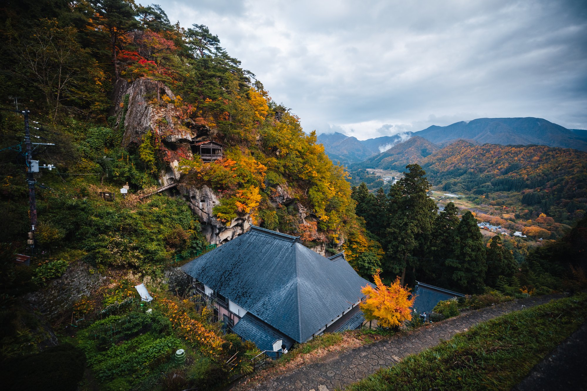 Halls of Risshaku-ji built into the cliff face above the Yamadera valley in autumn