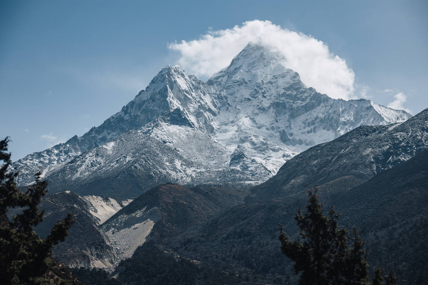 Ama Dablam rising above juniper-covered ridges under a clear blue sky