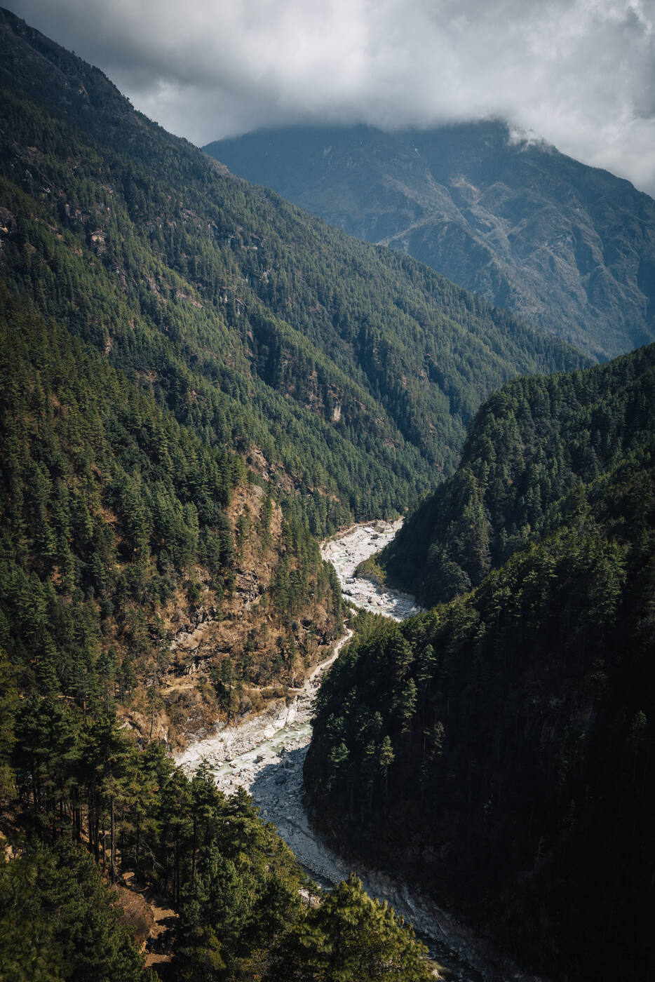 The Dudh Koshi River winding through a deep forested gorge between mountain ridges