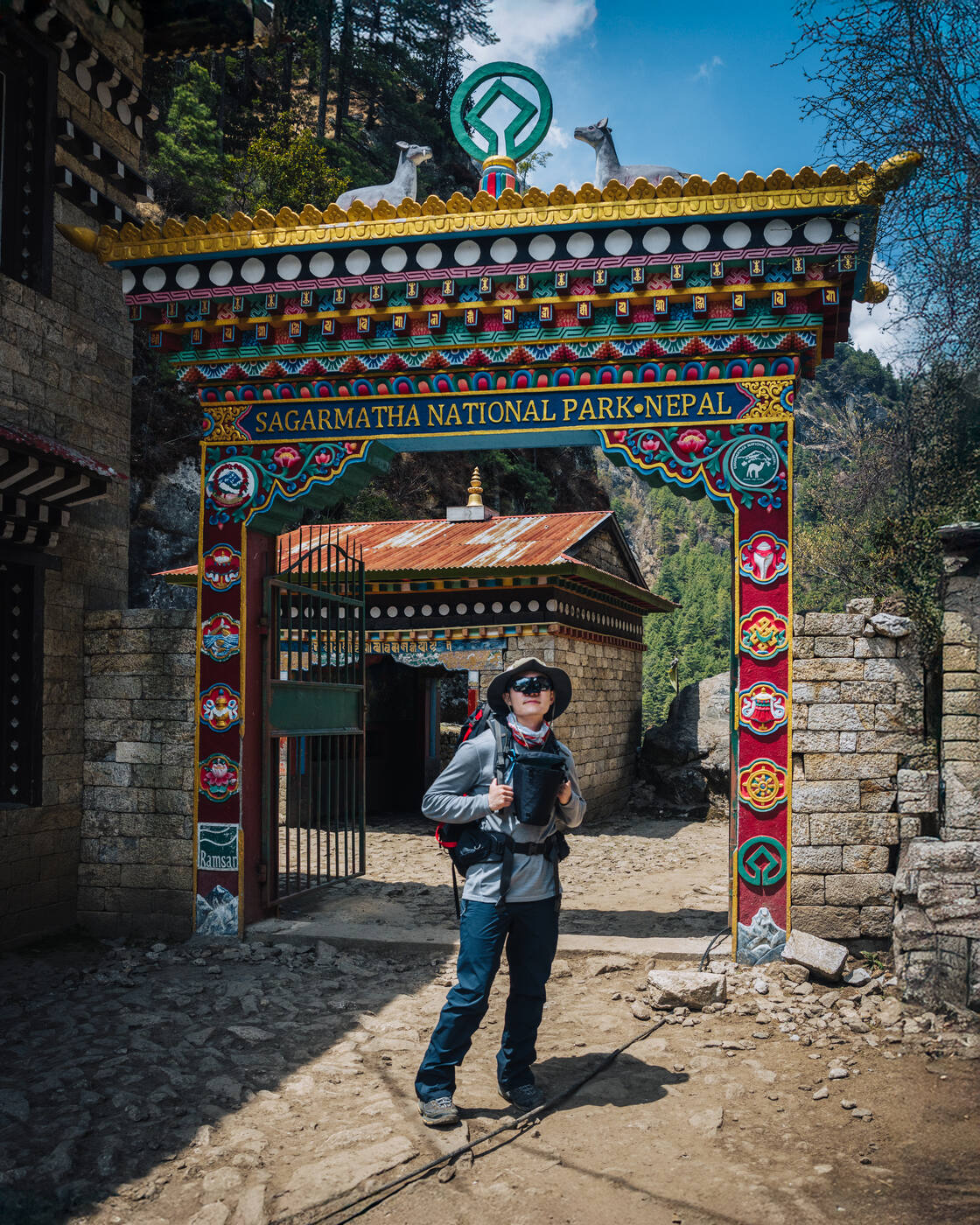 Jason in front of the ornate Sagarmatha National Park gate, painted Tibetan motifs framing the entrance