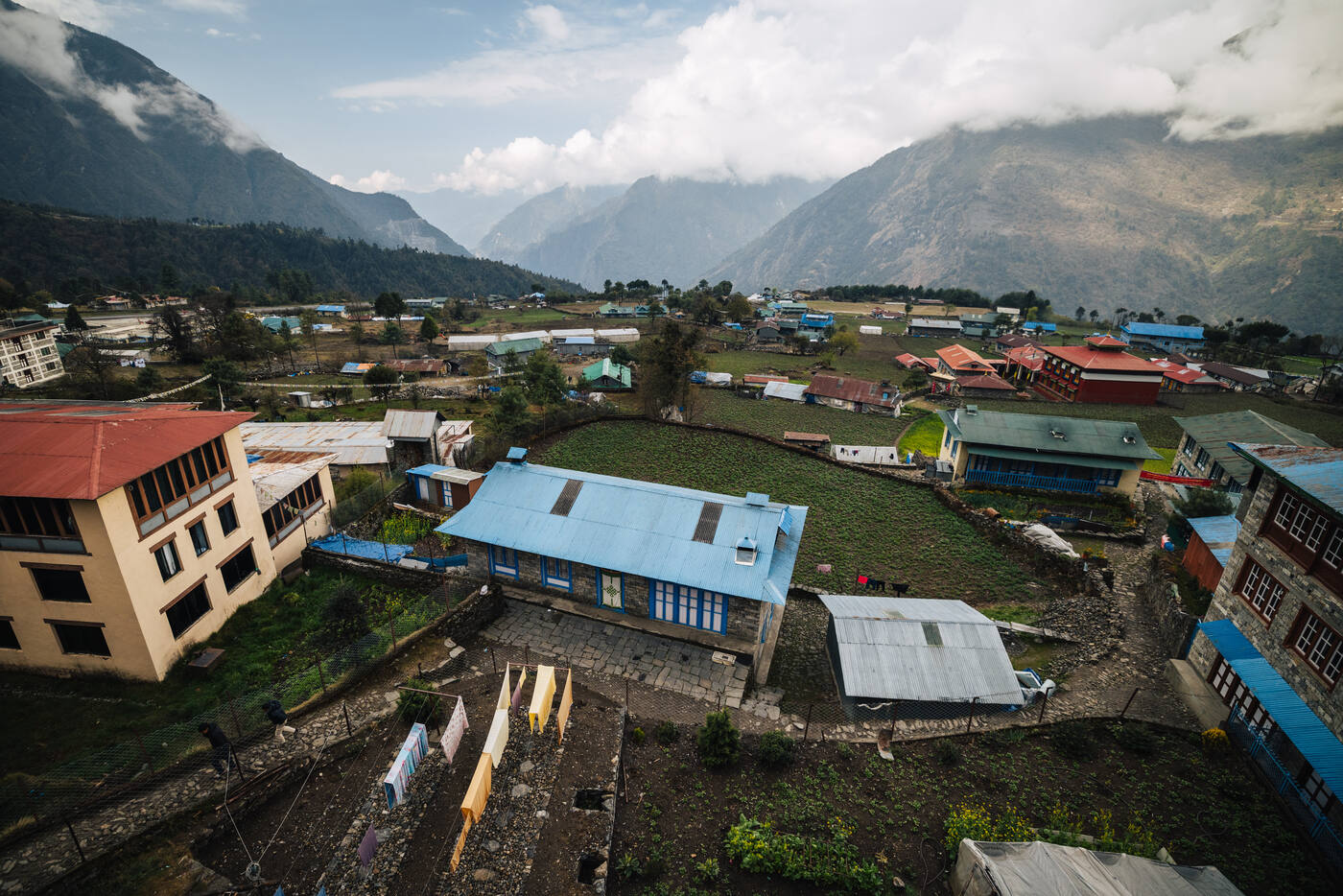 Lukla village from above, lodges and gardens nestled below the surrounding mountain ridges