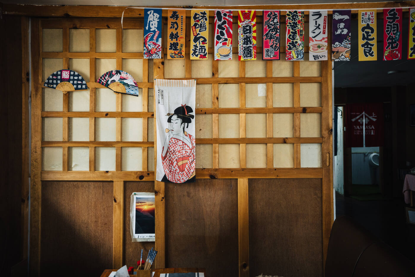 Interior of a Japanese-style restaurant in Namche — wooden lattice walls and colorful noren banners