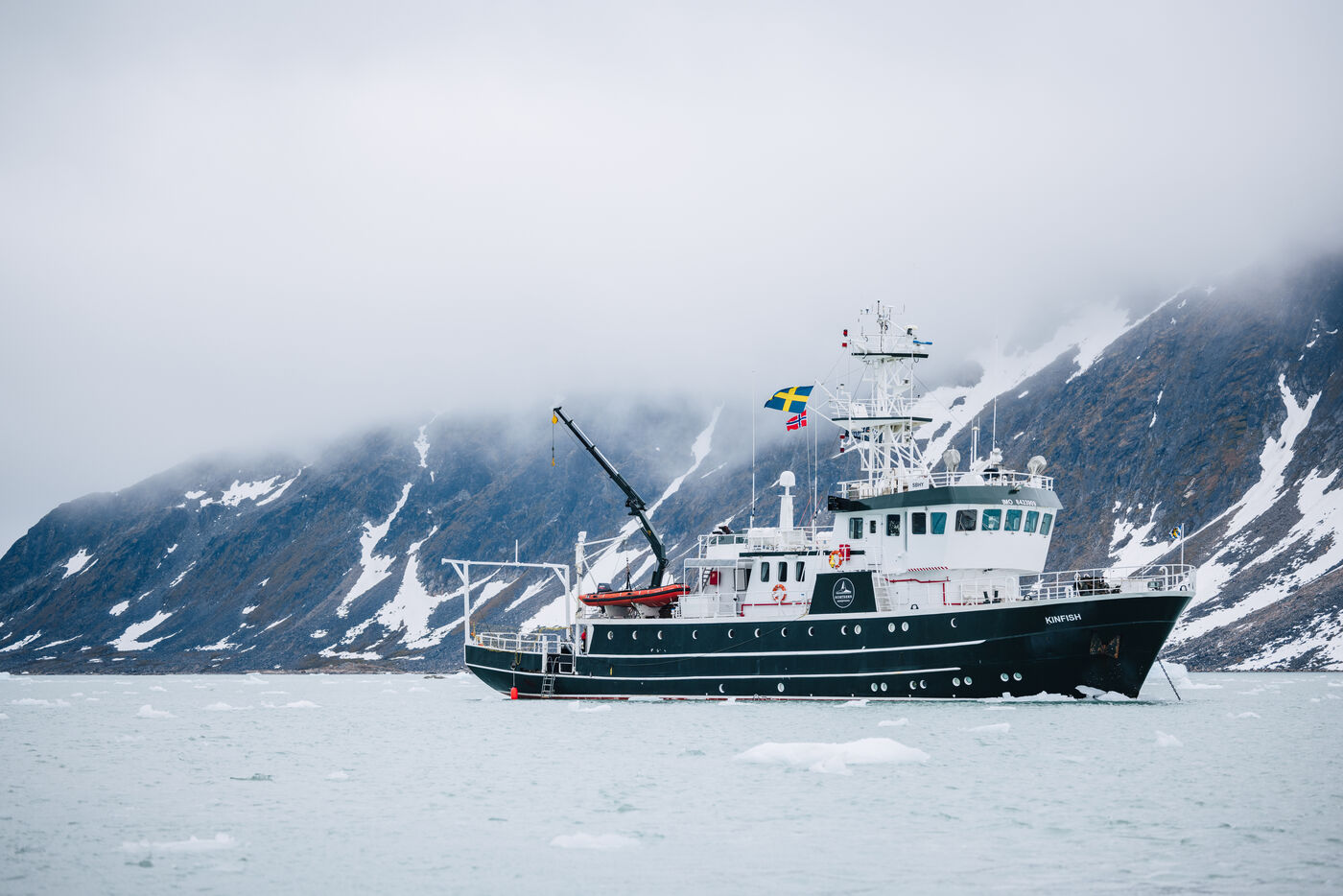 The Kinfish broadside with snow-streaked mountains behind