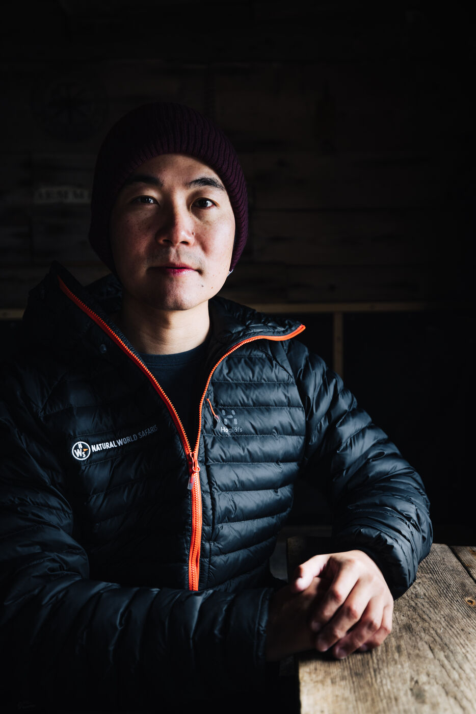 Portrait of a man in a black and orange jacket and beanie