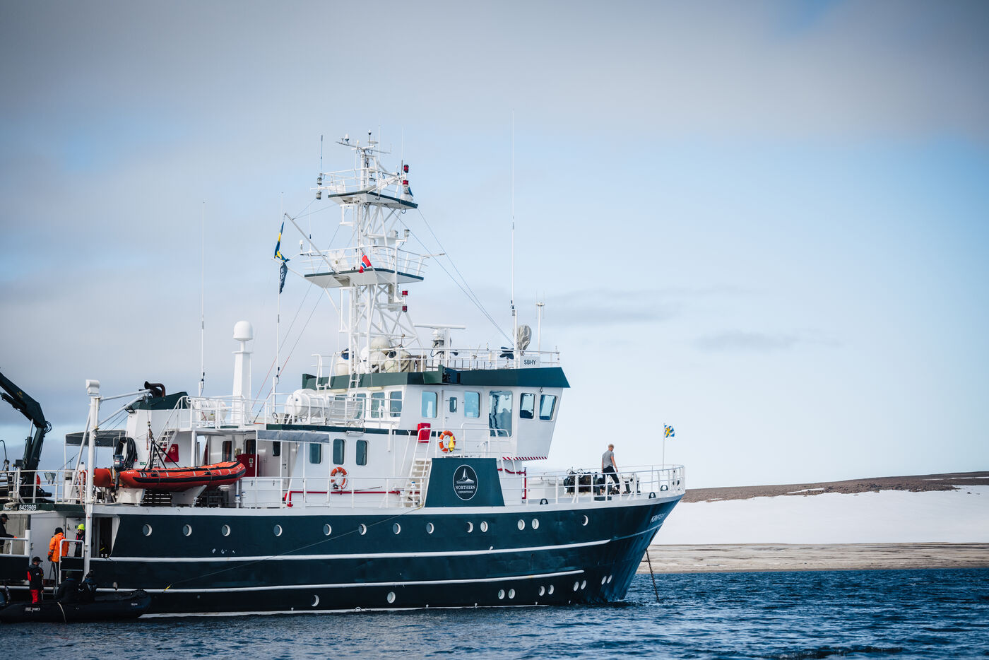 The Kinfish ship anchored in calm Arctic waters, broadside view showing the full vessel