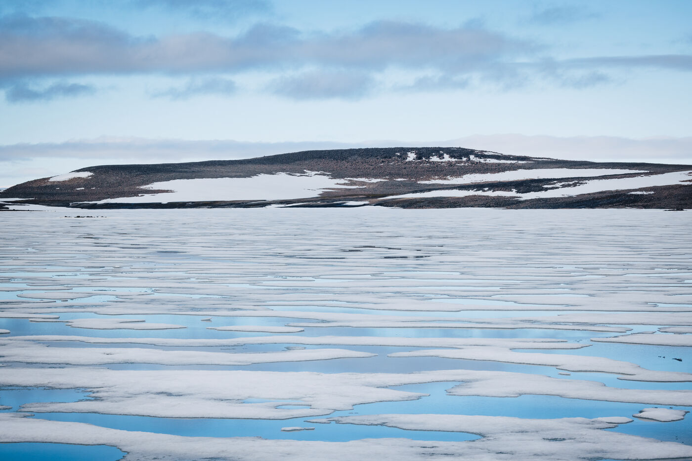 Low flat-topped island beyond a field of pack ice