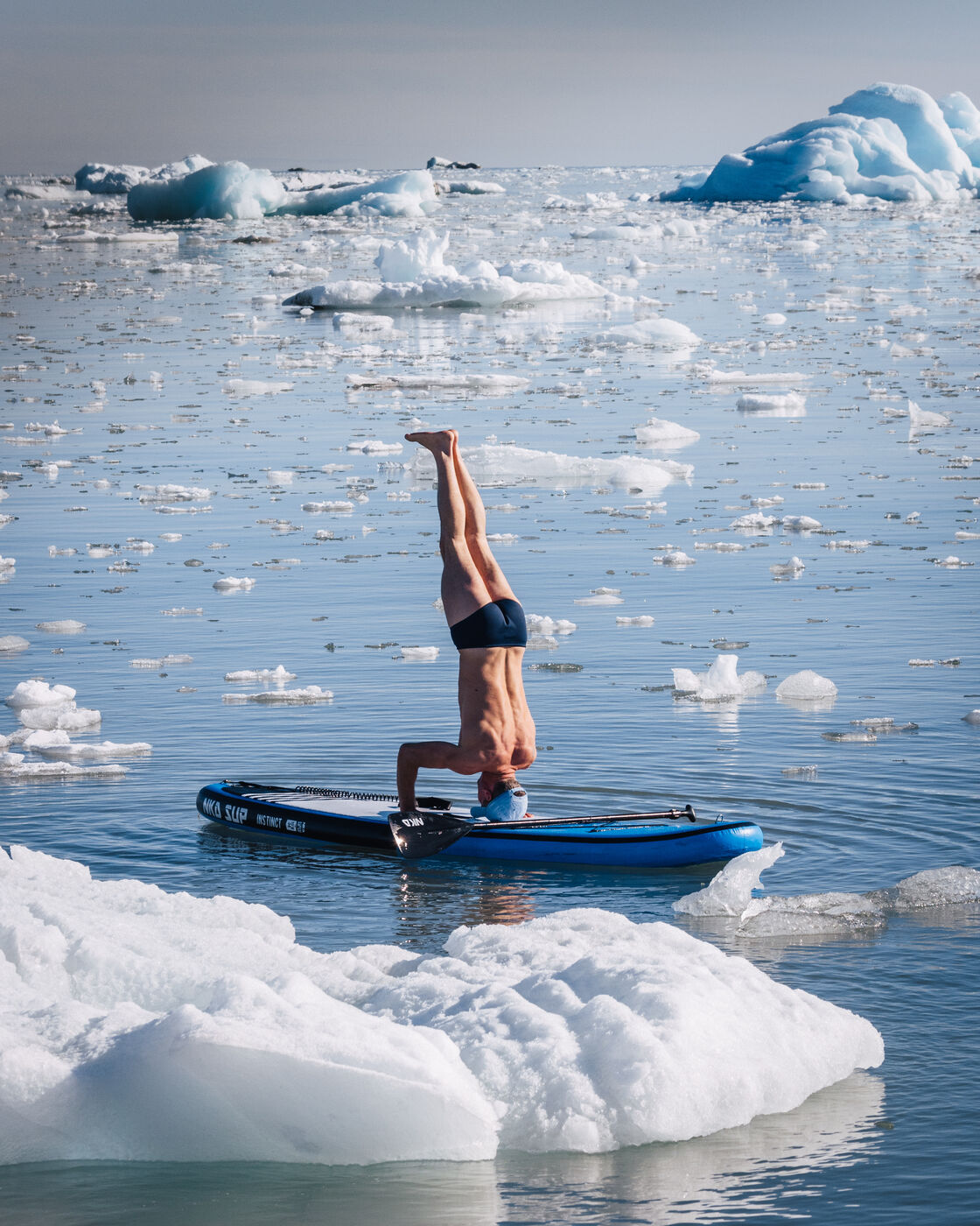 Headstand on a paddleboard among the ice floes