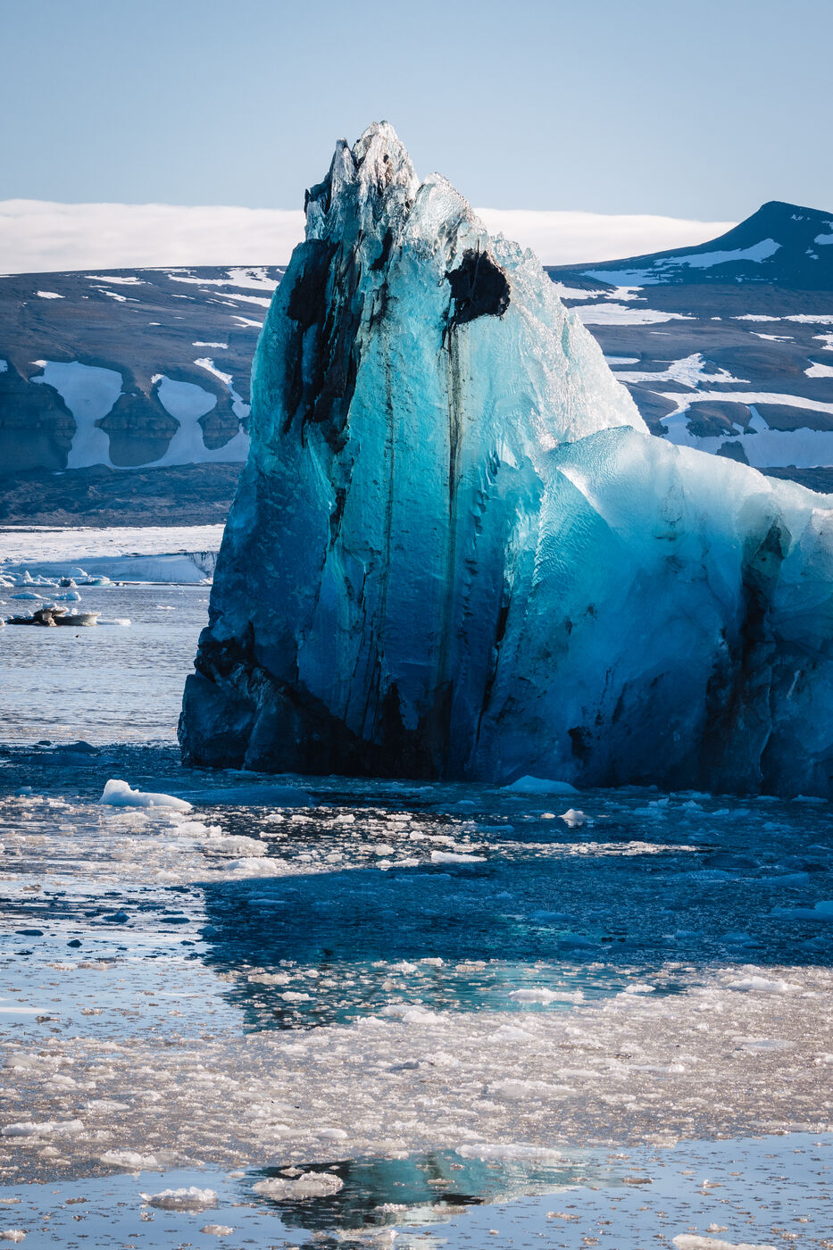 Dramatic turquoise iceberg with water lapping at base