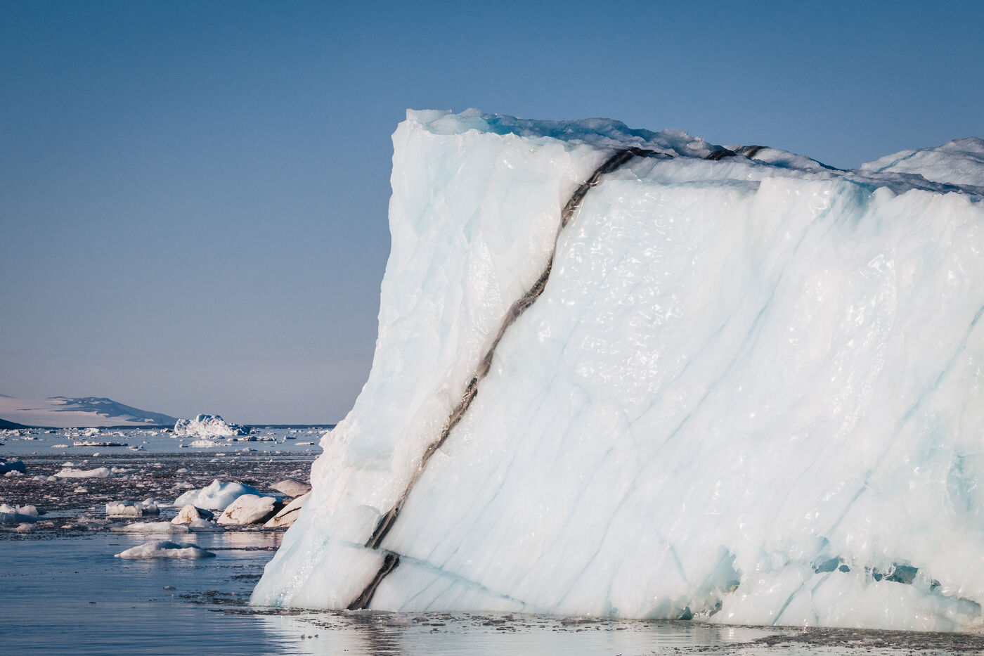 Large tabular iceberg with a dark diagonal band of debris
