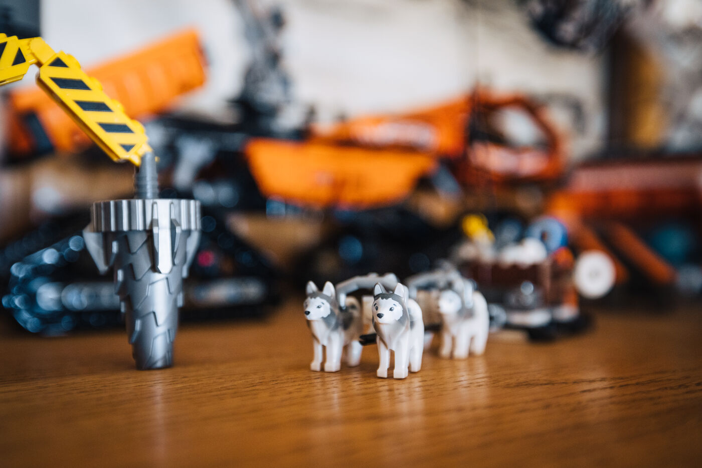 Lego huskies and an orange Lego vehicle on a wooden table inside the station