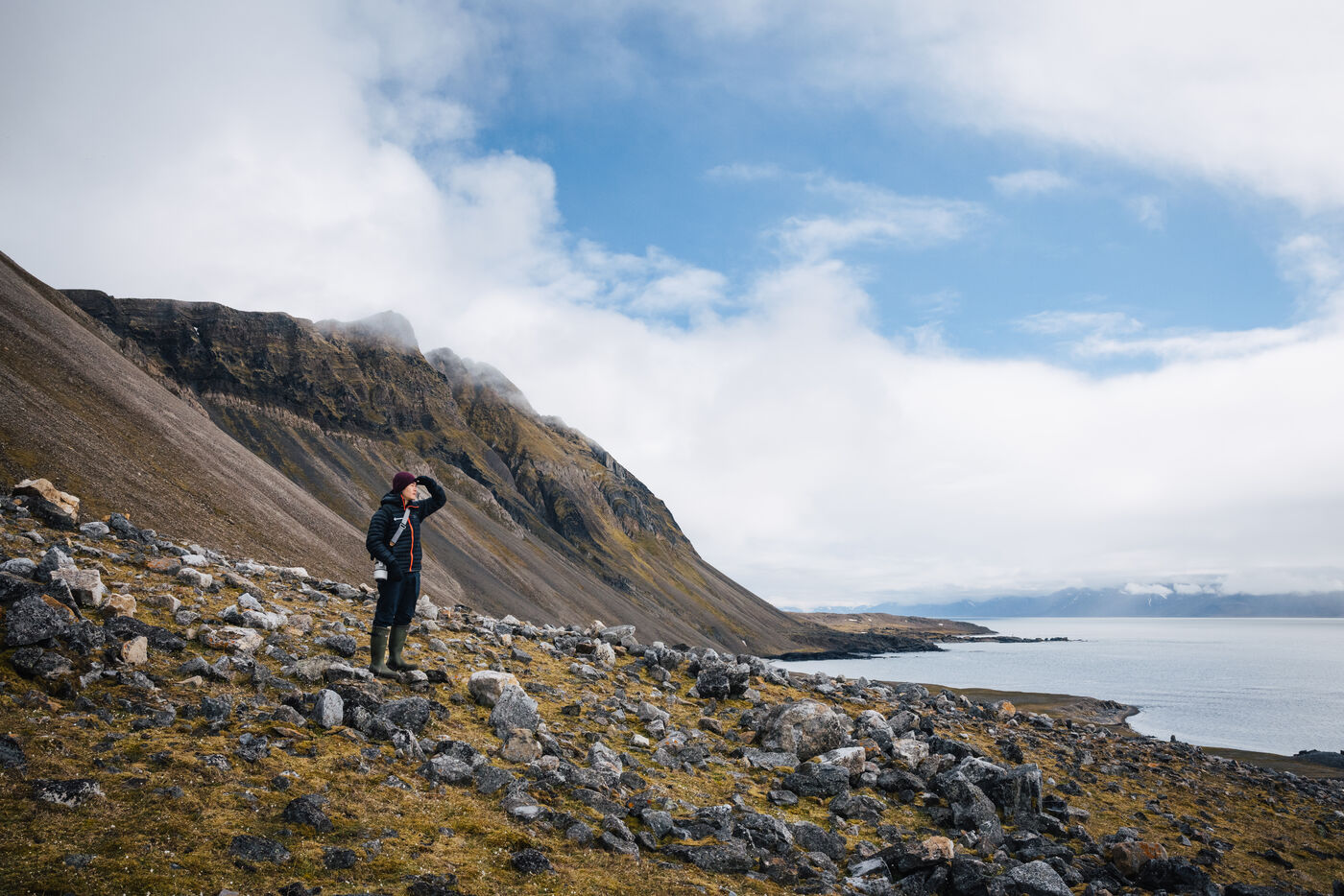 Lone hiker on vast tundra surrounded by Arctic landscape