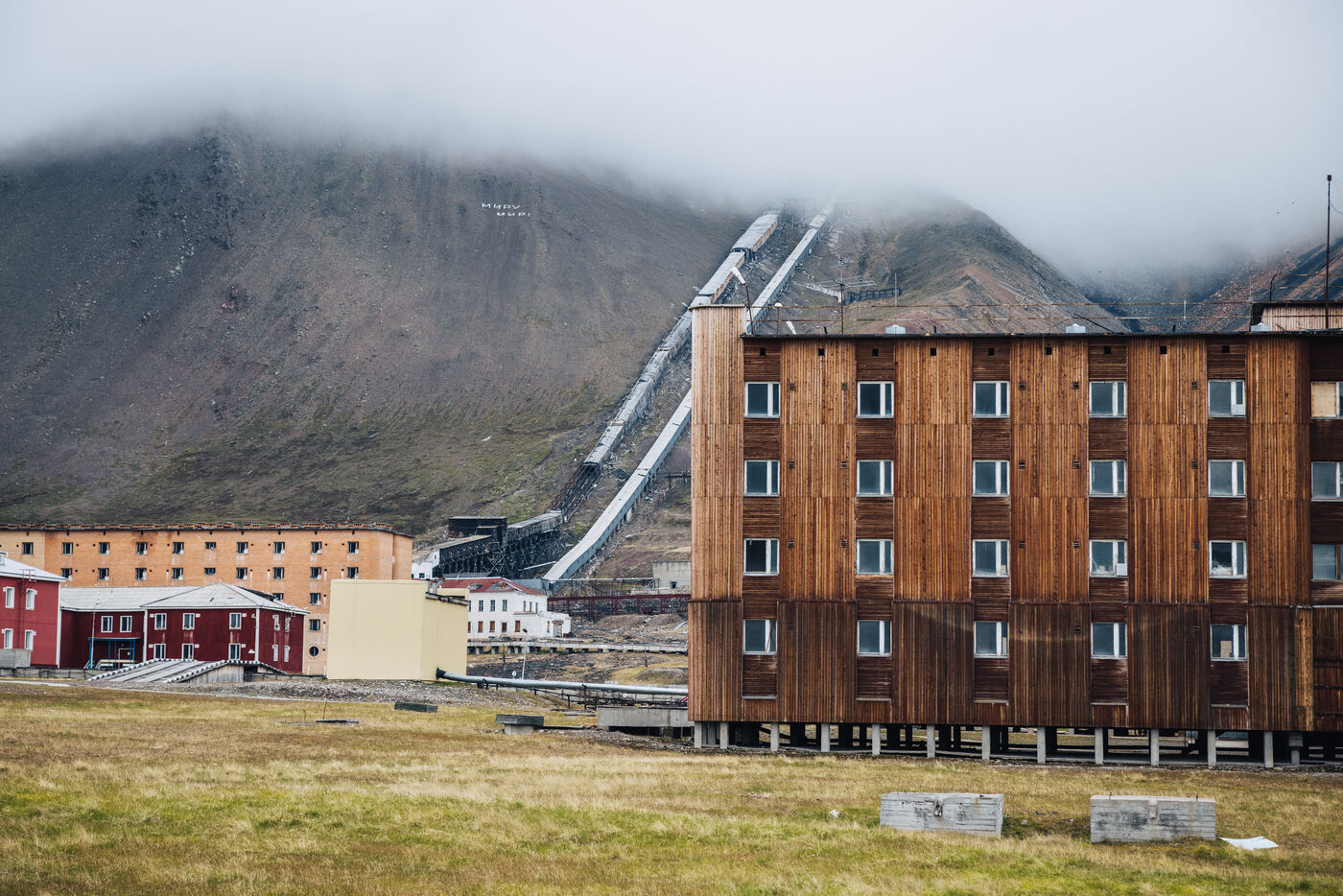 Wooden-clad apartment block with the mine conveyor climbing the slope behind