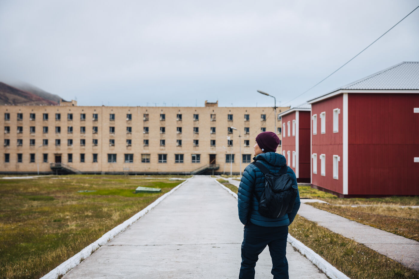 Person standing in empty plaza with residential buildings