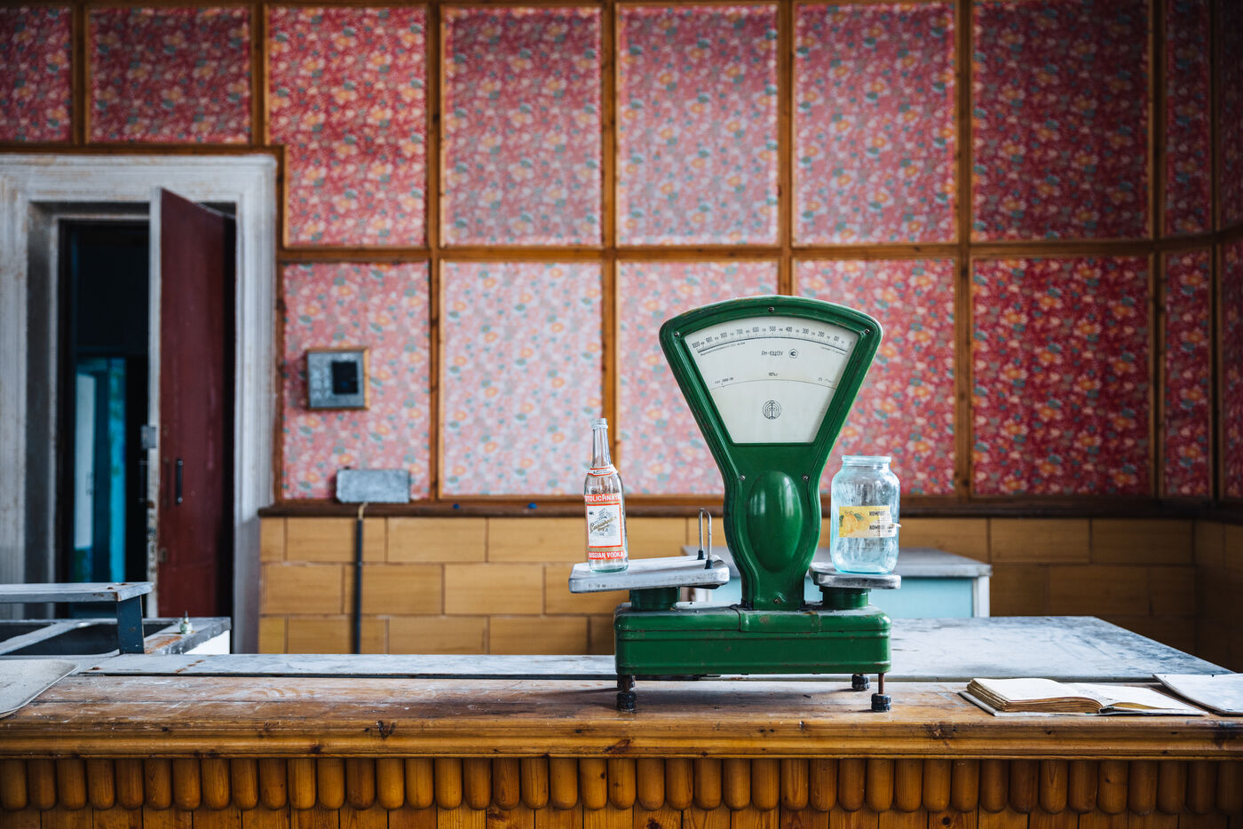 Green weighing scale and bottles on a wooden canteen counter