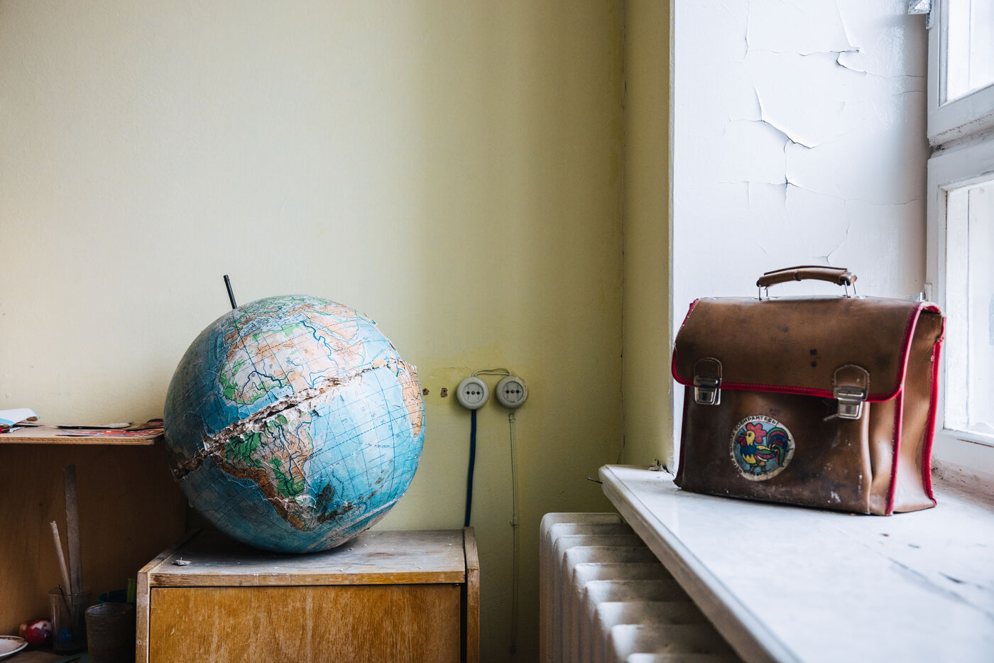 Old globe and leather briefcase on windowsill