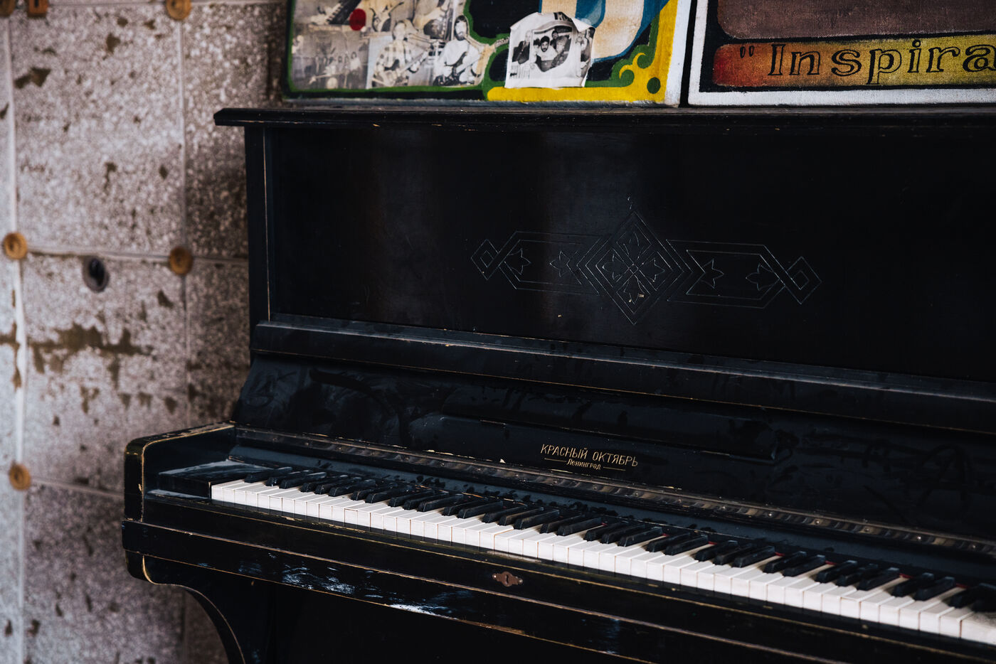 Black upright piano in deteriorated room
