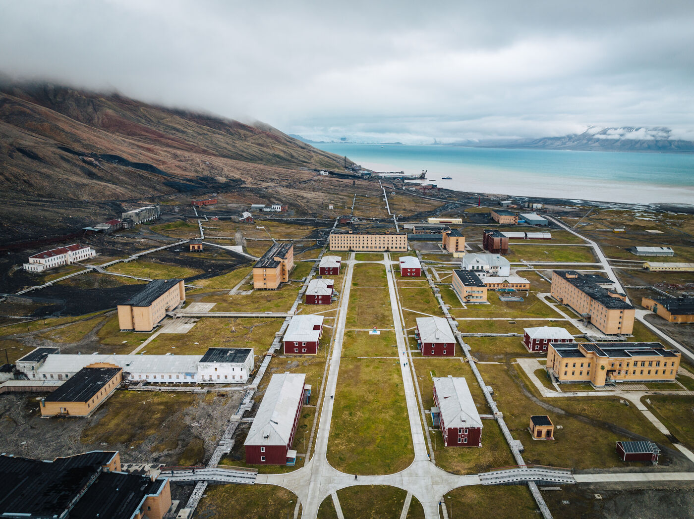 Settlement in grid pattern with red buildings and mountains