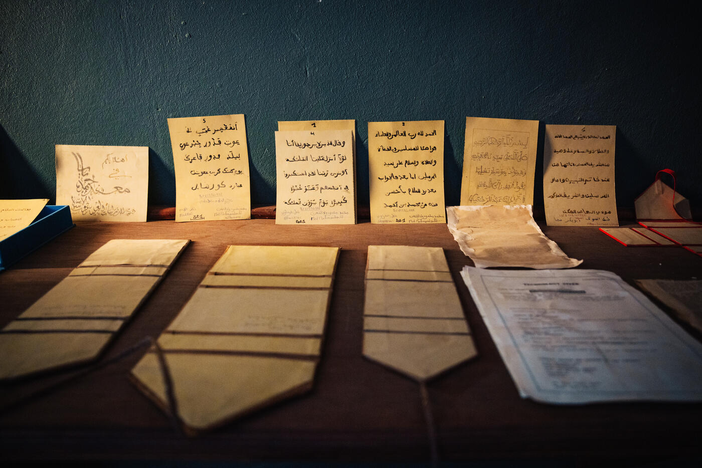 Ancient manuscripts displayed on table with Arabic text