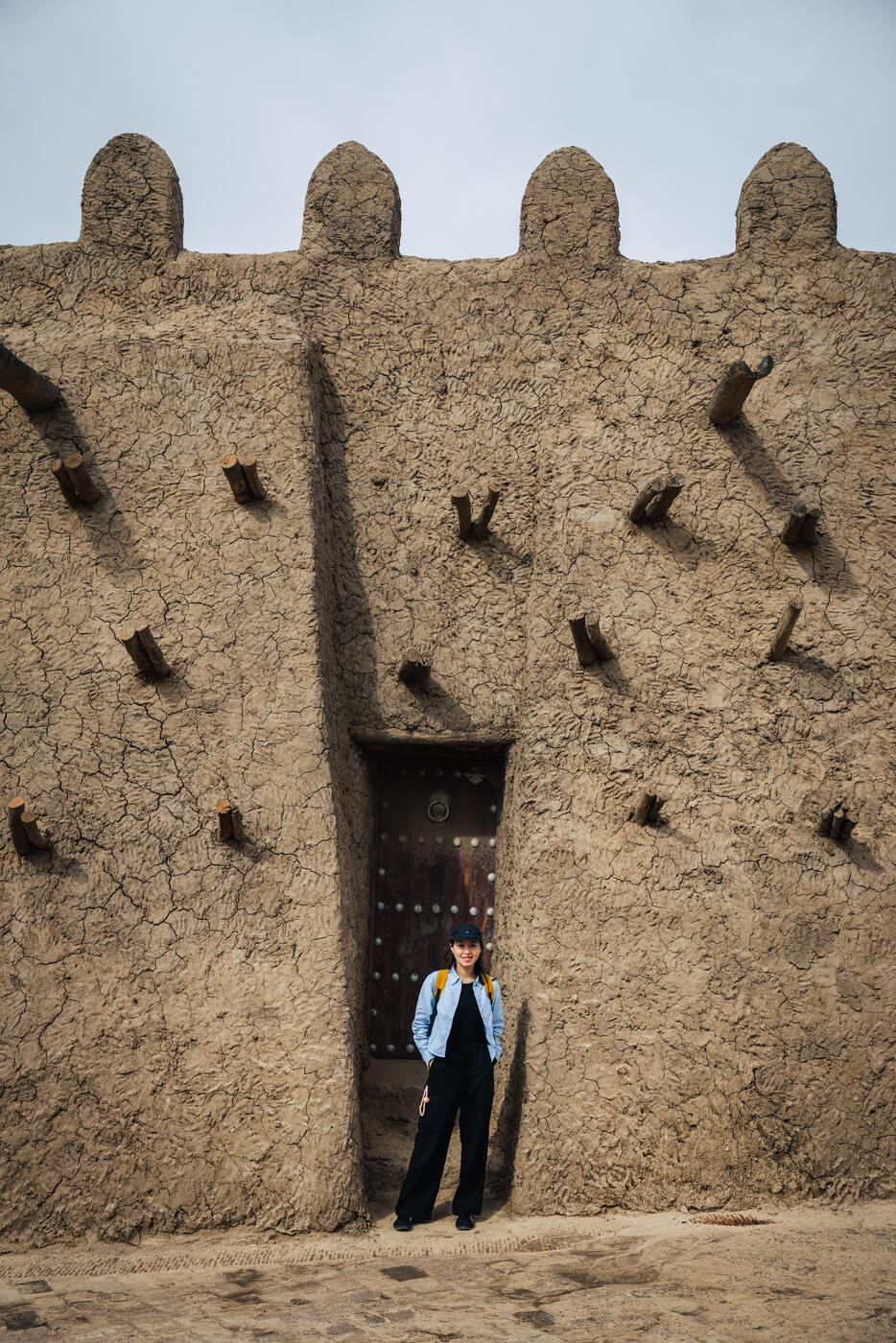 Person standing at ancient mosque doorway