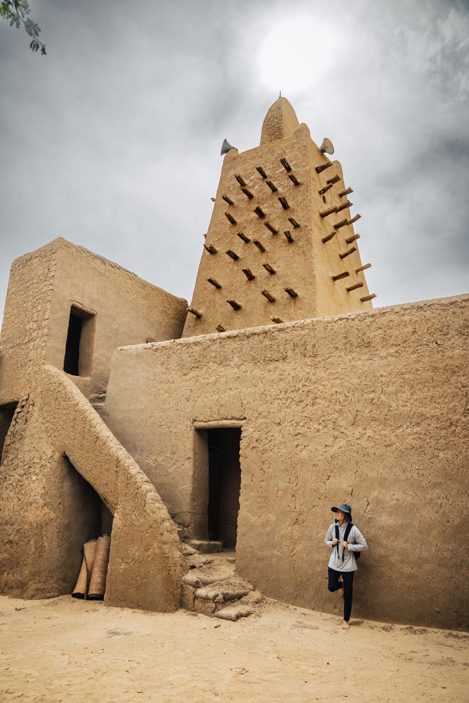 Person at mosque exterior with minaret