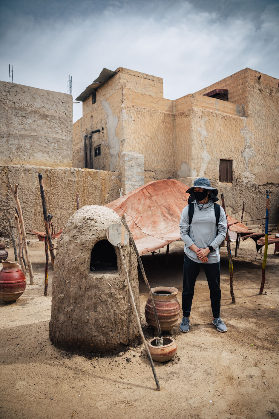 Person at clay oven in mud-brick courtyard