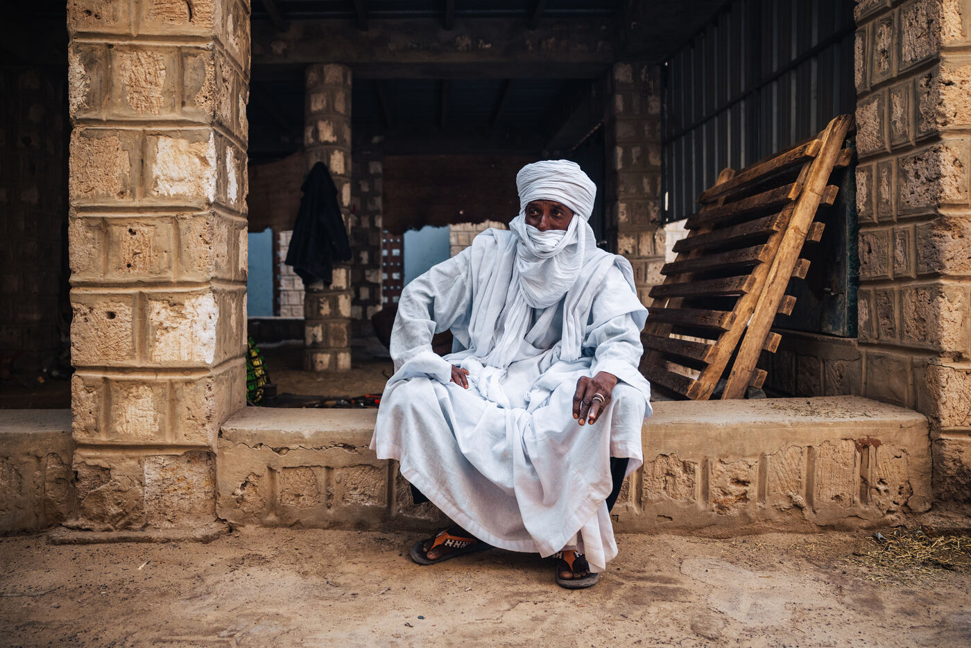 Tuareg elder in white turban sitting in doorway
