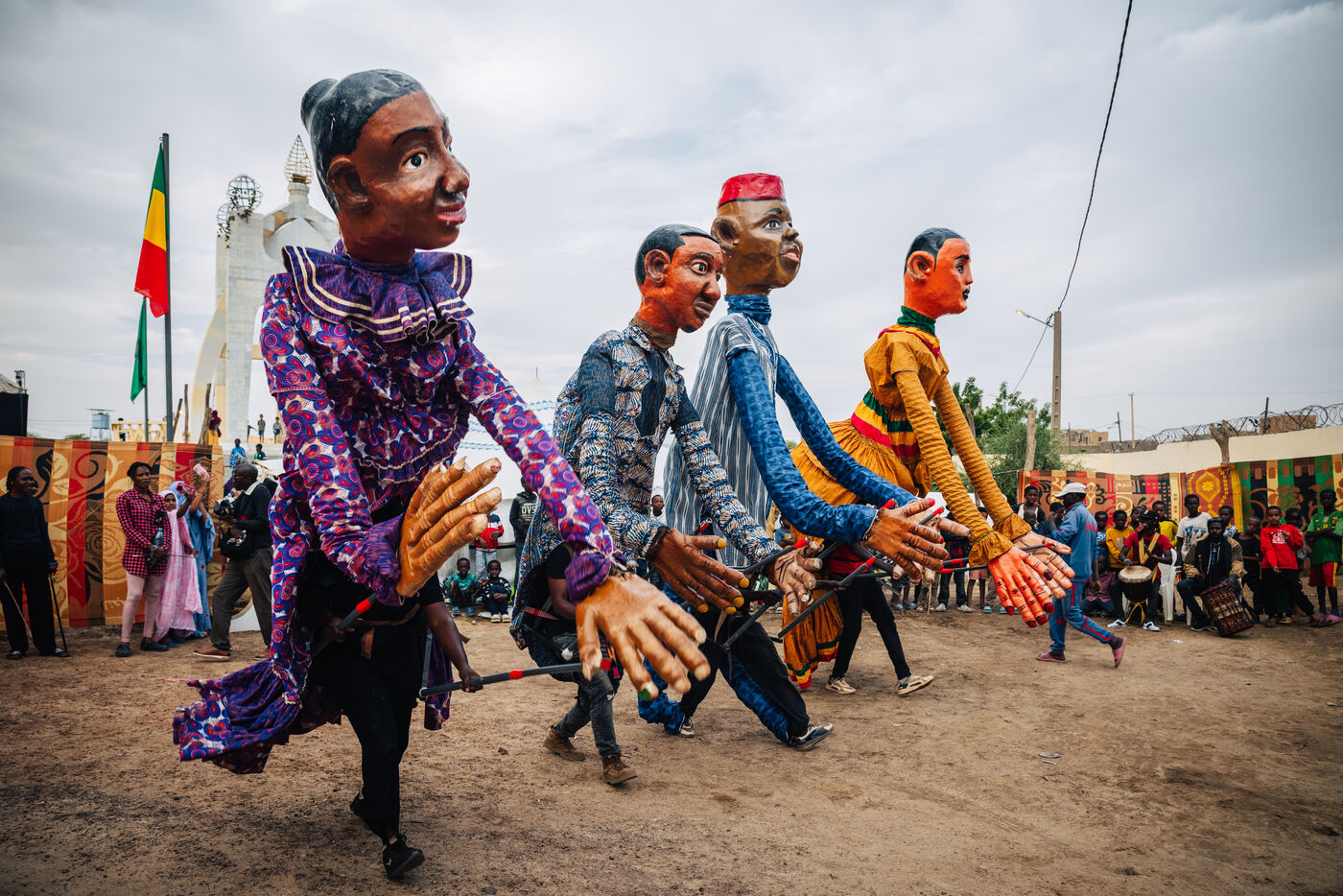 Giant puppet figures parading through streets of Timbuktu