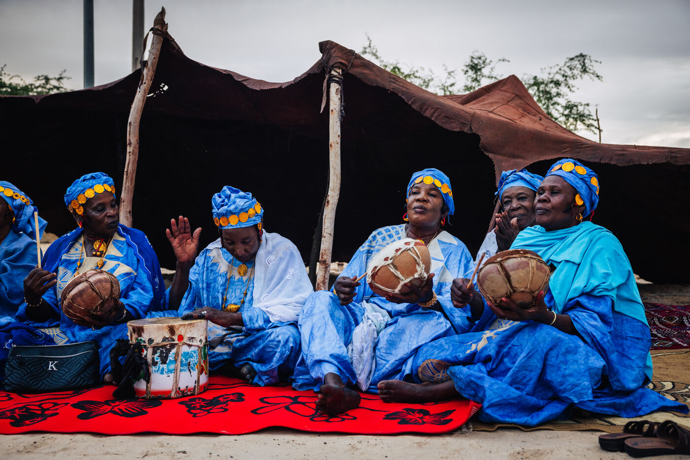 Women musicians in blue playing traditional drums