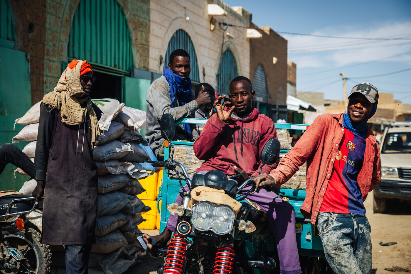 Young men on motorcycle with goods