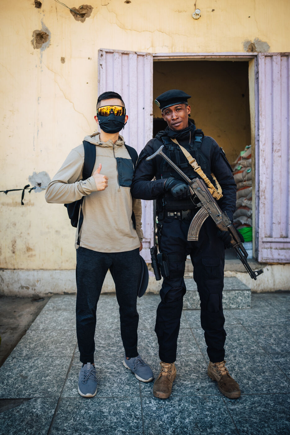 Person posing with armed soldier