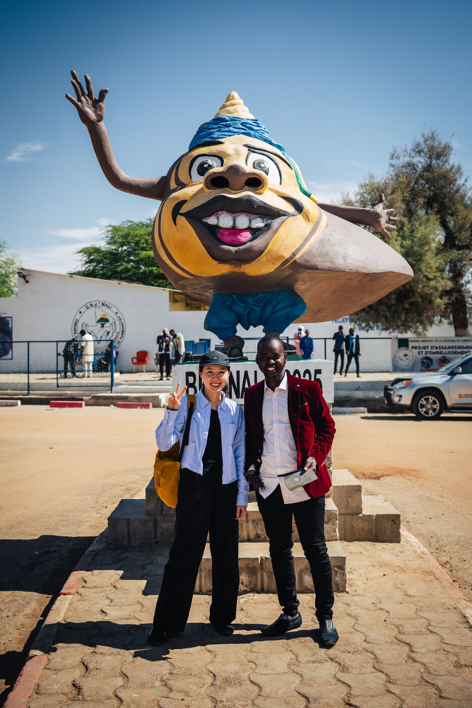 Two people at Biennale mascot statue