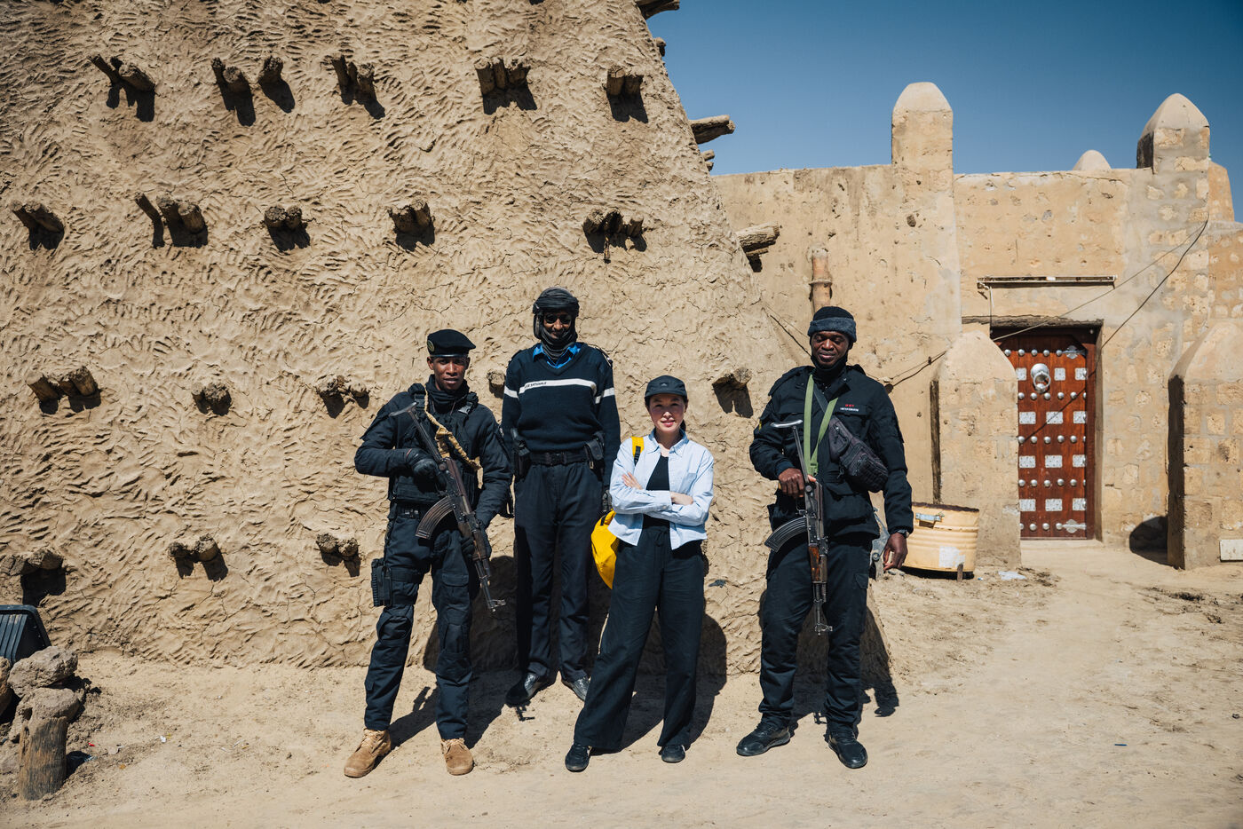 Person with three armed guards at mosque