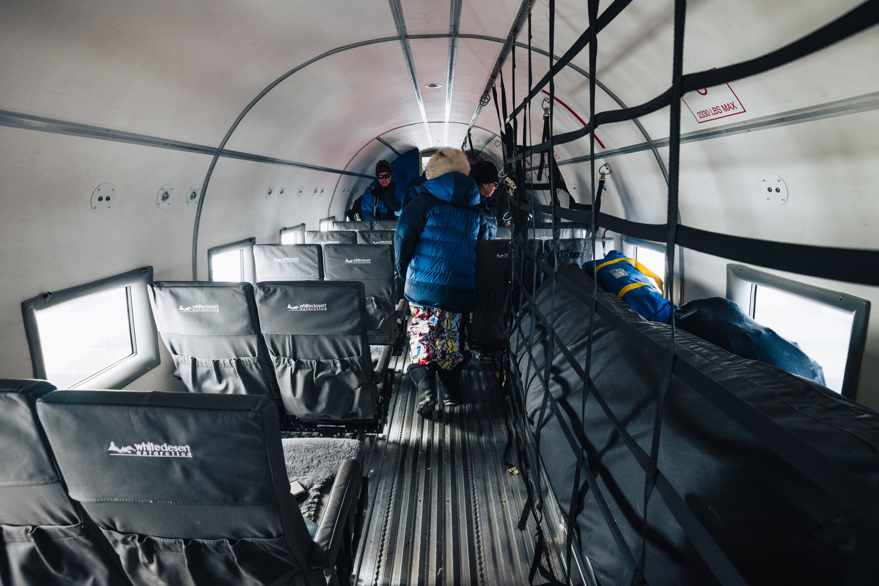View down the aisle of the Basler cabin with cargo and passengers during the flight to the South Pole