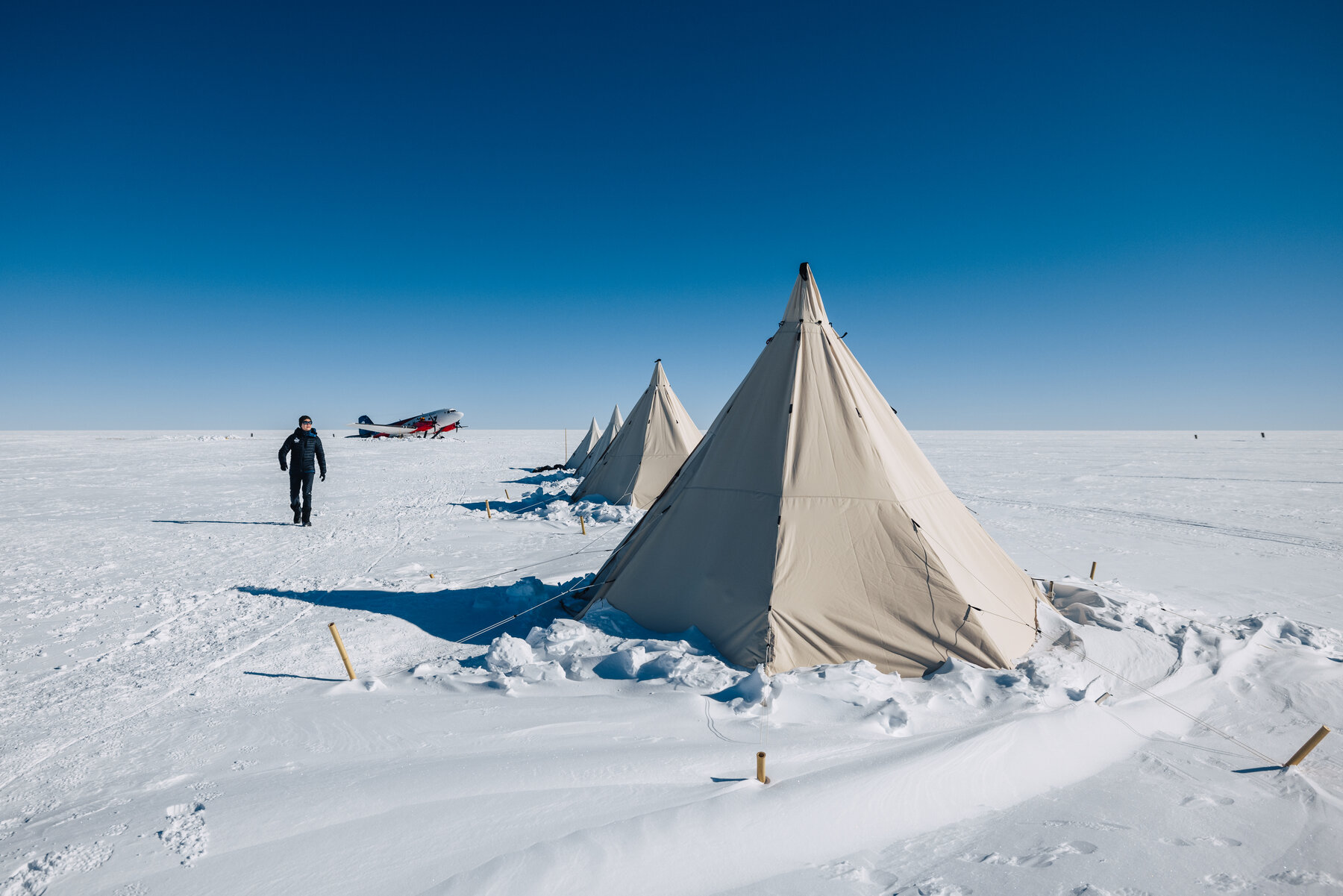 Dixie's Camp teepees with the Basler BT-67 aircraft parked on the snow runway in the background