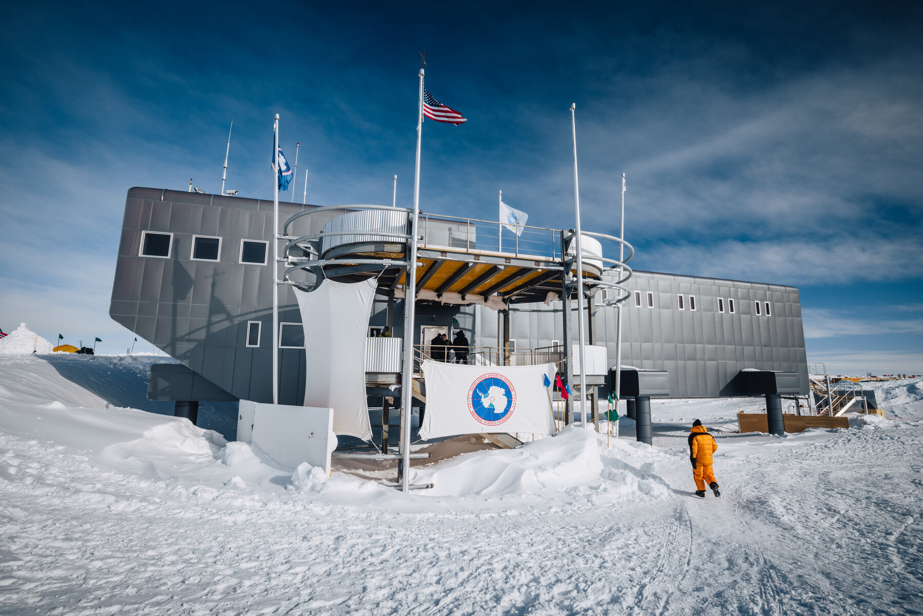 The elevated Amundsen-Scott South Pole Station built on stilts above the ice plateau under deep blue sky