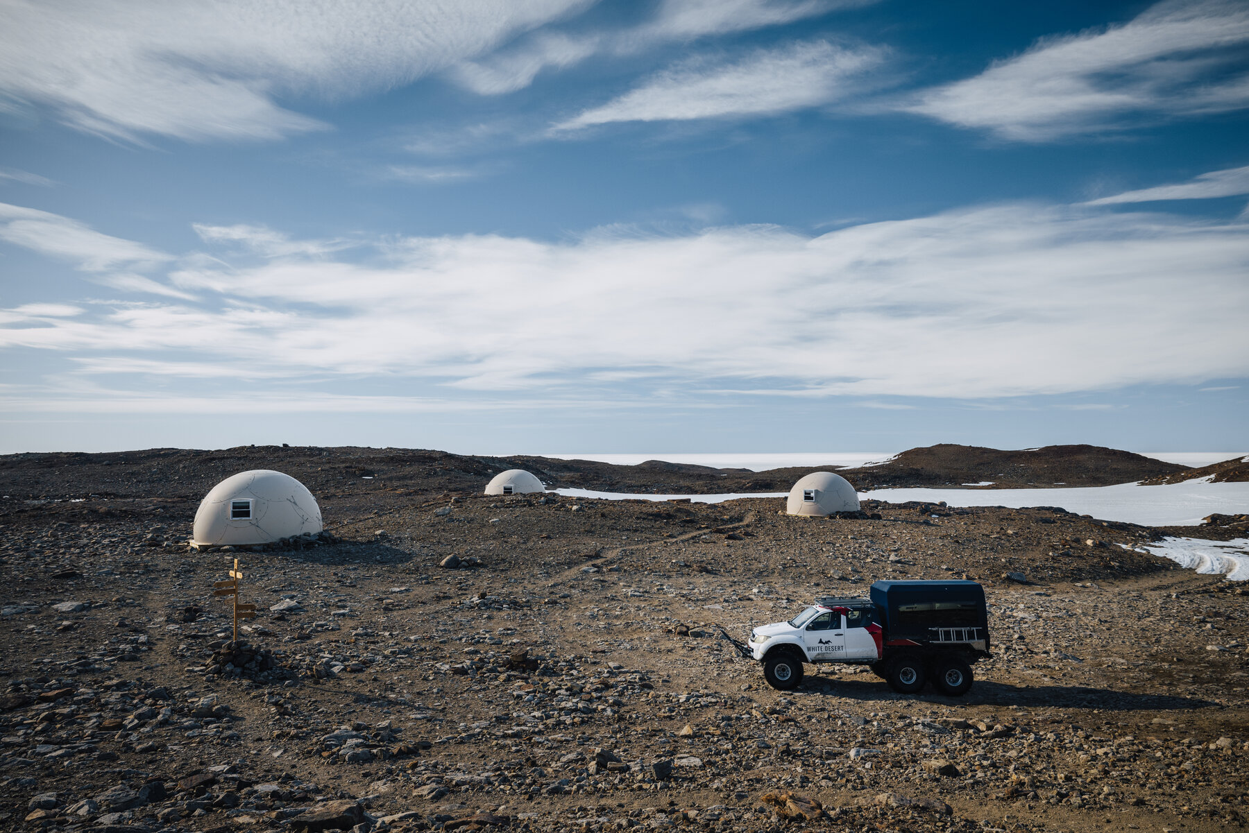 Whichaway pods scattered across the rocky outcrop with a white support truck parked on the access road