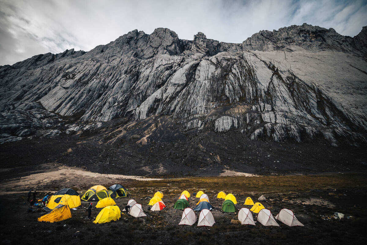Panoramic view of numerous tents spread across the high valley with mountains