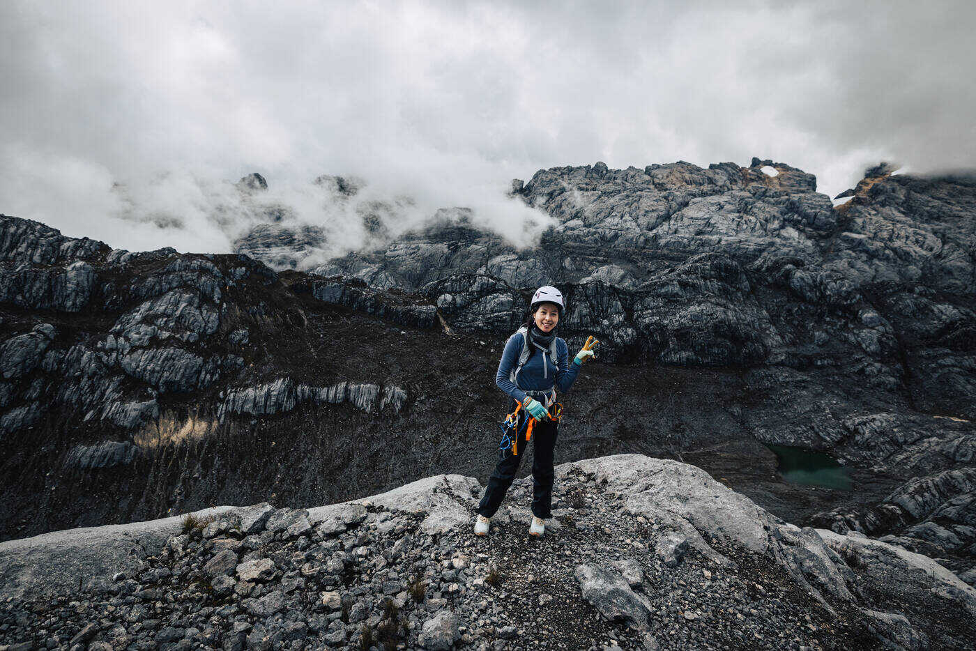 Single climber on barren plateau with vast mountain landscape