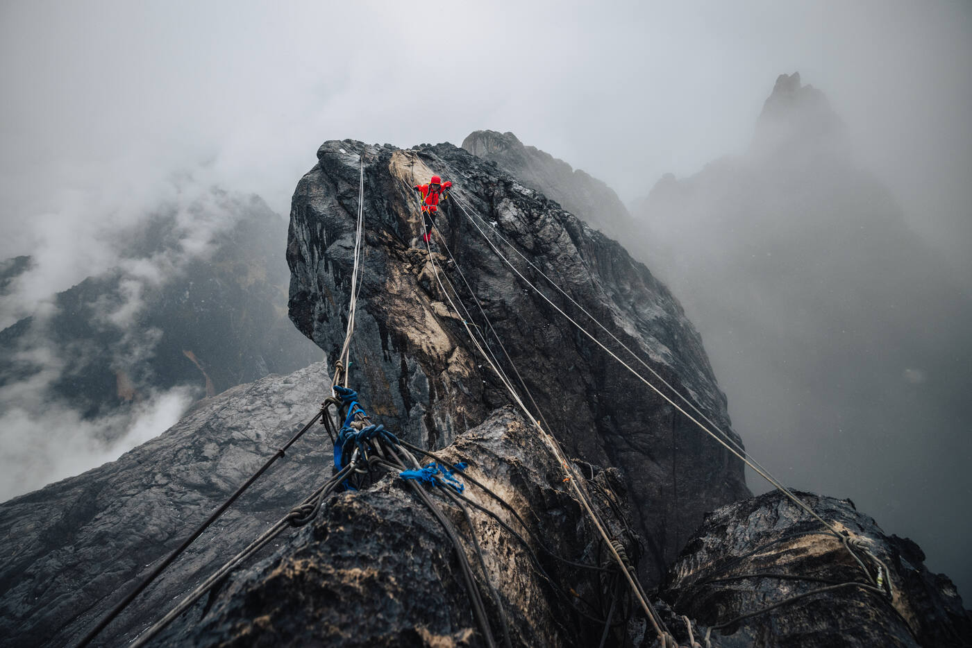 Climbers ascending misty ridge near summit