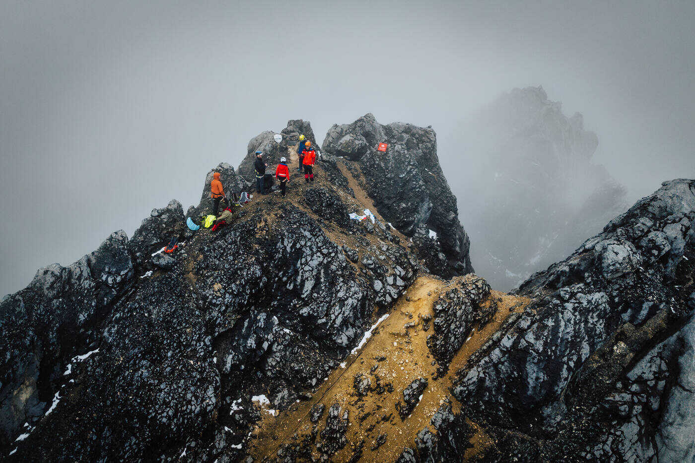 Drone aerial of climbers on multiple rock formations at summit area