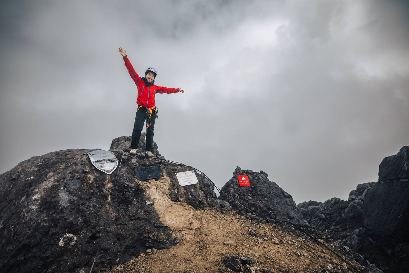 Climber with arms raised in celebration on summit