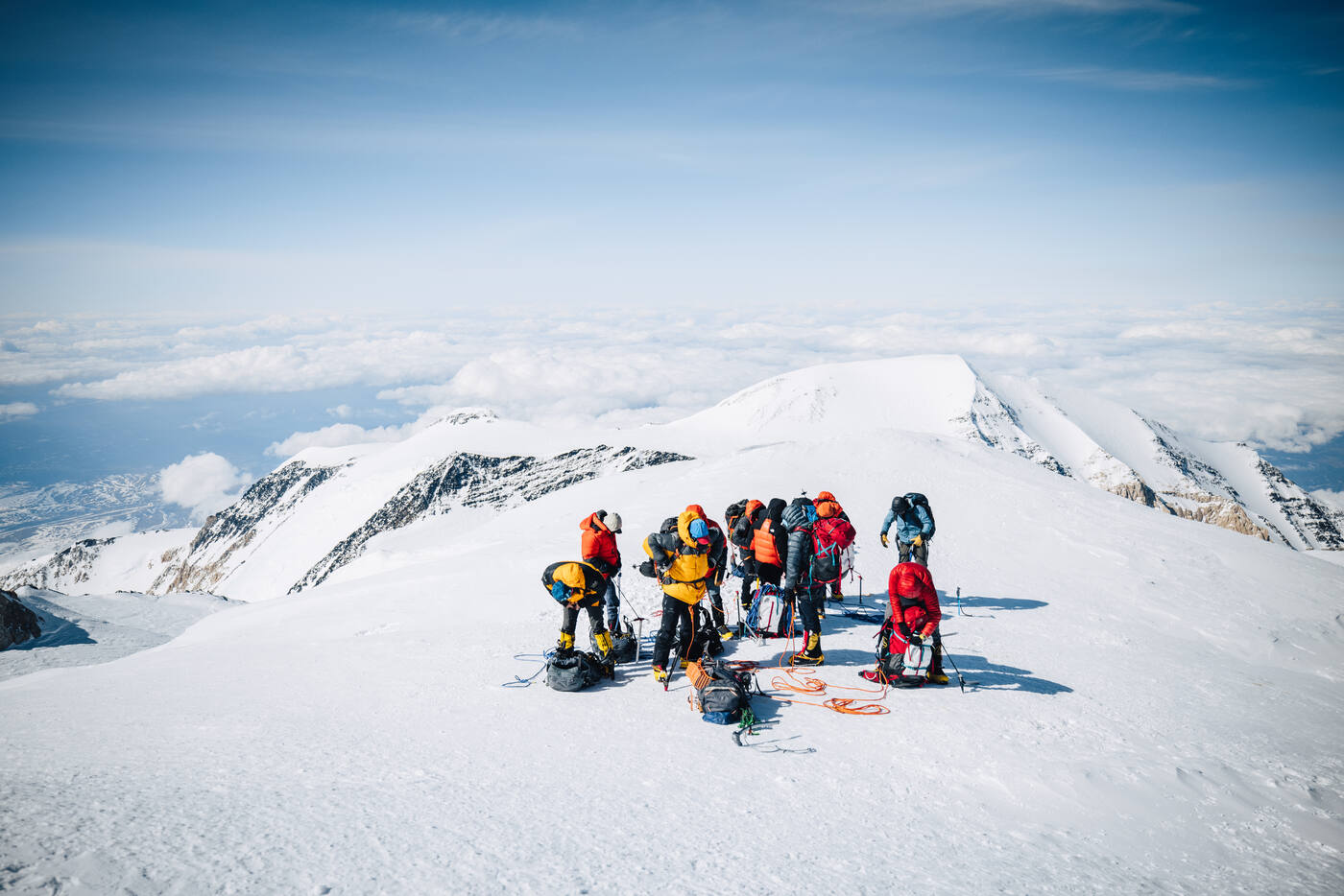 Full climbing team gathered at Denali summit celebrating with gear and ropes
